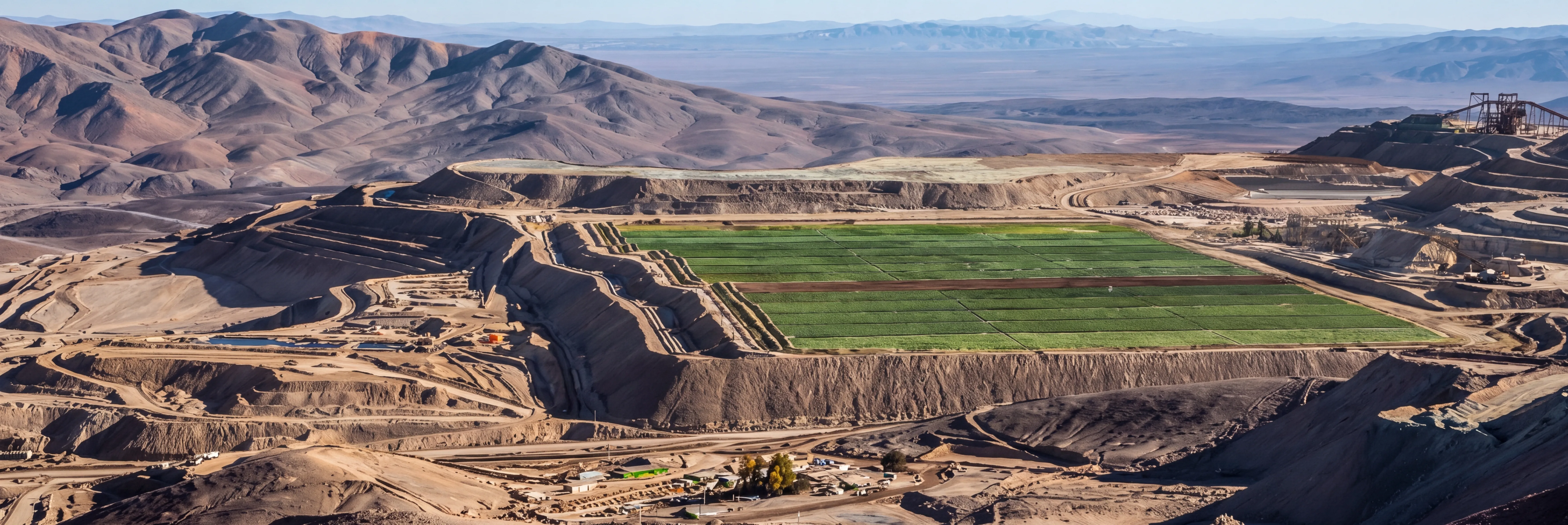 Panorámica de faena minera con paño verde de revegetación